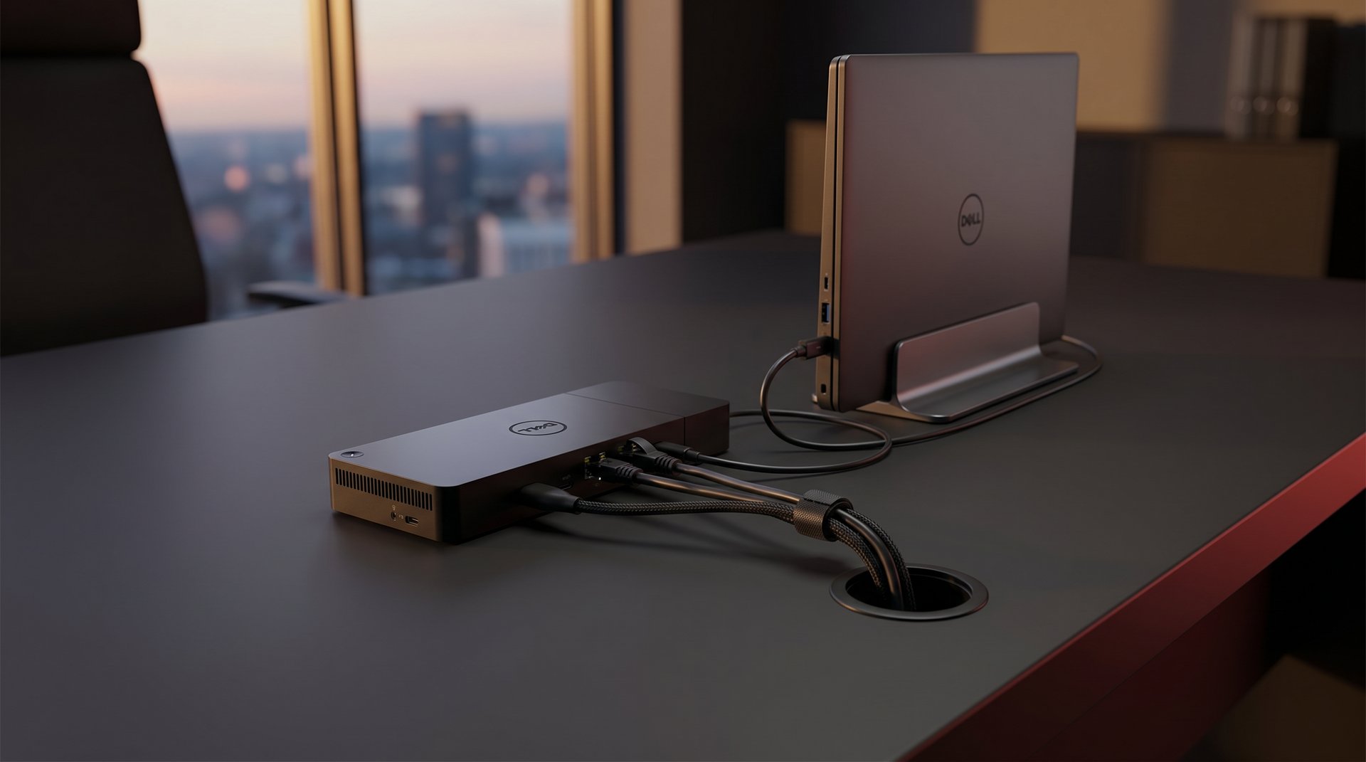 Dell Thunderbolt dock and Dell laptop in a vertical stand with a single tidy cable bundle routed through a desk grommet